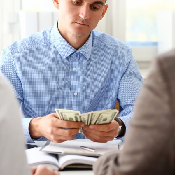 Un conseiller financier professionnel souriant et faisant un geste explicatif lors d'un rendez-vous, illustrant le moment où un prêteur privé devient la meilleure option pour un client.